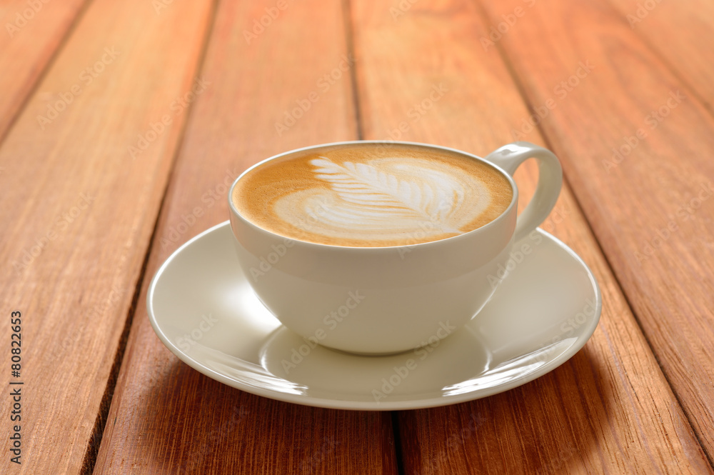 A cup of cafe latte on wooden background A cup of cafe latte on wooden background