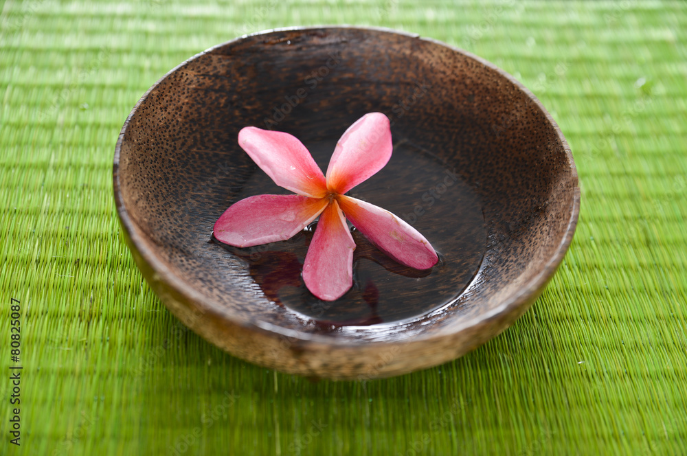 frangipani flower in water wooden bowl on mat frangipani flower in water wooden bowl on mat