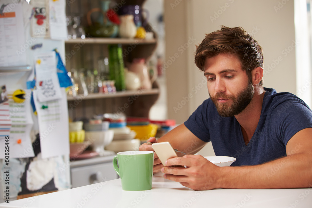 Man Eating Breakfast Whilst Using Mobile Phone Man Eating Breakfast Whilst Using Mobile Phone