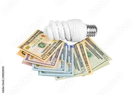 Energy saving light bulb and money on white