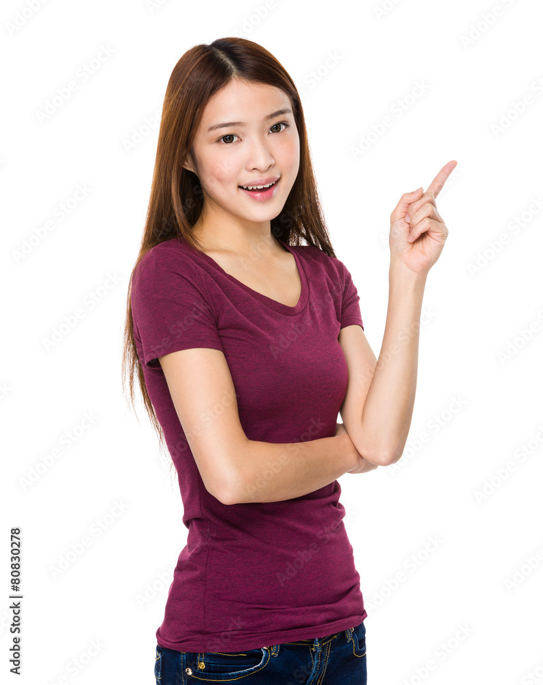 Smiling young woman pointing upwards