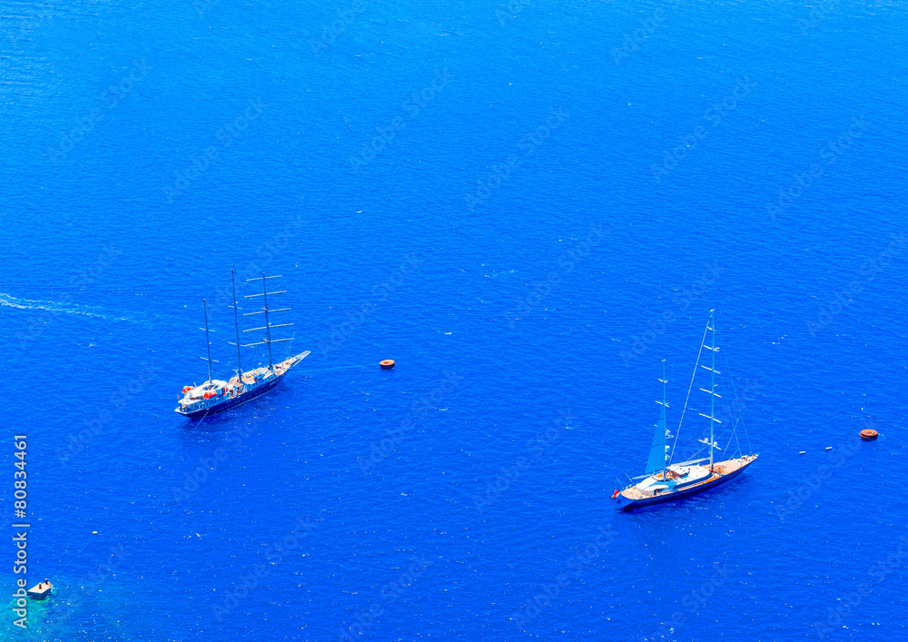 2 big sailing boats under Fira of Santorini island in Greece