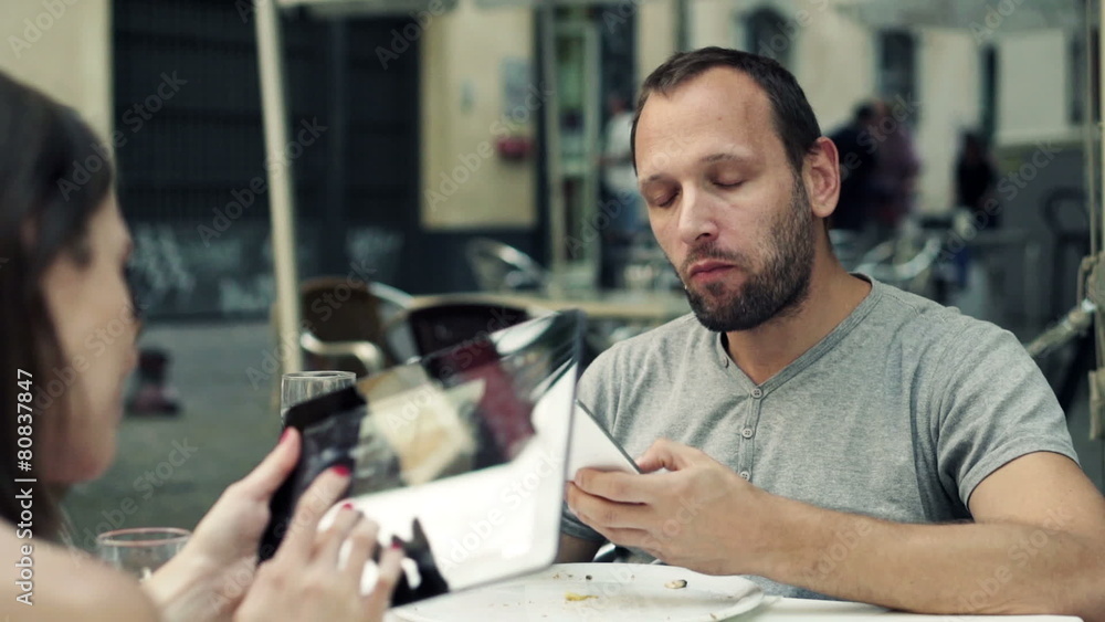 Couple with tablet computer and smartphone eating pizza Couple with tablet computer and smartphone eating pizza