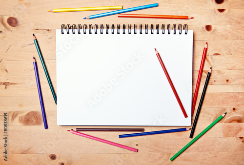 drawing block with copy space on wood table with colored pencil