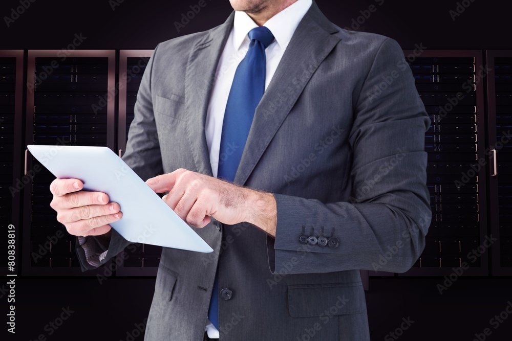 Composite image of businessman using his tablet pc Composite image of businessman using his tablet pc