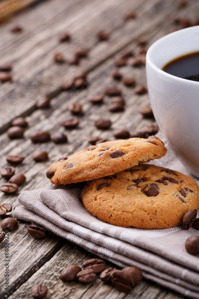 Tasty cookies and coffee cup on a wooden table.