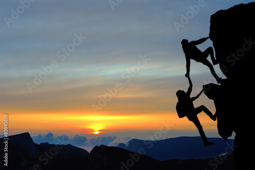 Teamwork of two people man and girl on mountain