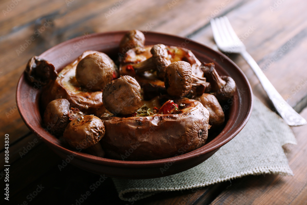 Baked potatoes with mushrooms in bowl on table close up Baked potatoes with mushrooms in bowl on table close up