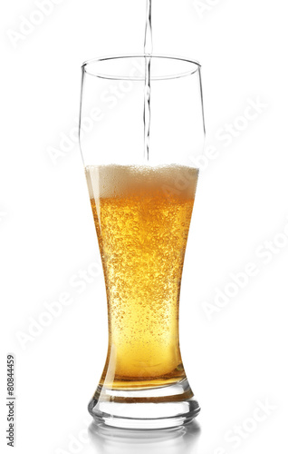 Pouring beer into glass isolated on white