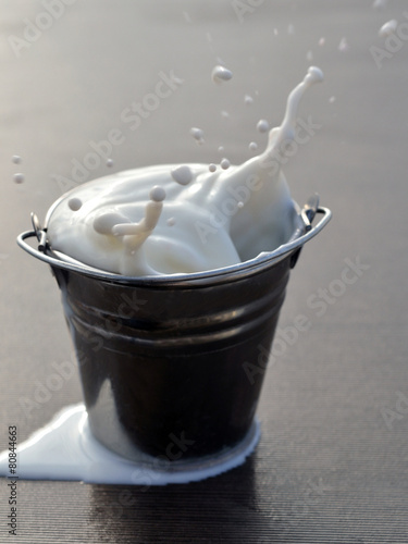 А splash of milk in a bucket.