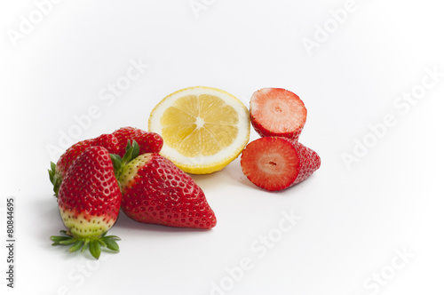 stil life of organic strawberries and lemon all cut