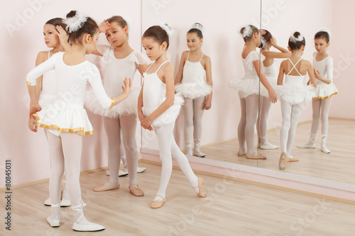 Group of six little ballerinas preparing for performance