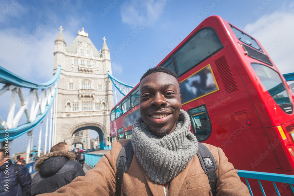 Naklejka premium Człowiek biorąc selfie w Londynie z Tower Bridge na tle