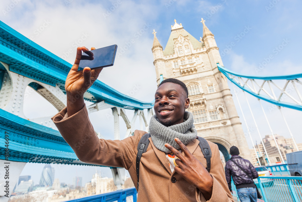 Naklejka premium Człowiek biorąc selfie w Londynie z Tower Bridge w tle