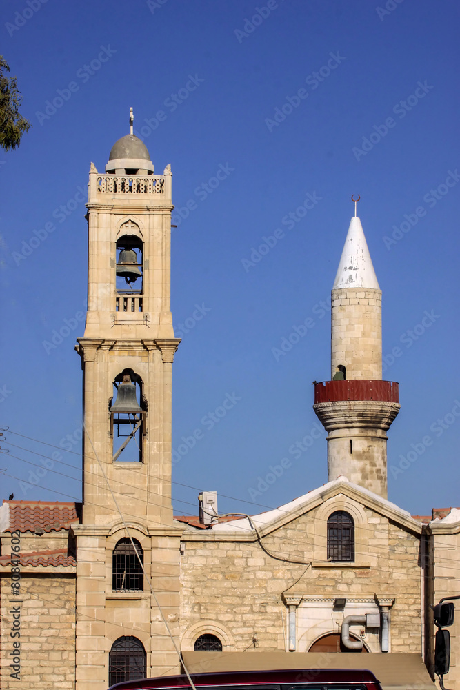 Orthodox church bell tower next to the mosque minaret, Cyprus