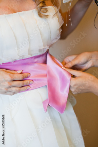 Helping the bride to put her wedding dress on