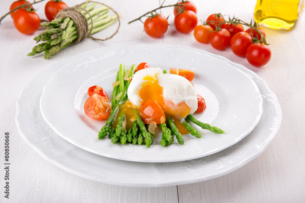 Green asparagus stems with soft-boiled egg, tomato and sauce. Green asparagus stems with soft-boiled egg, tomato and sauce.
