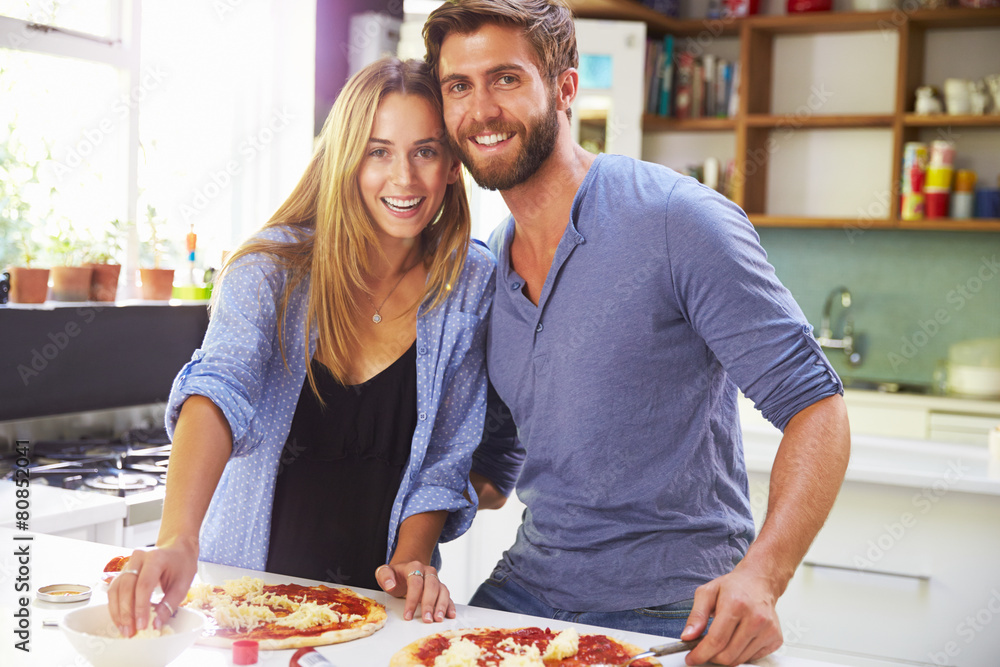 Young Couple Making Pizza In Kitchen Together