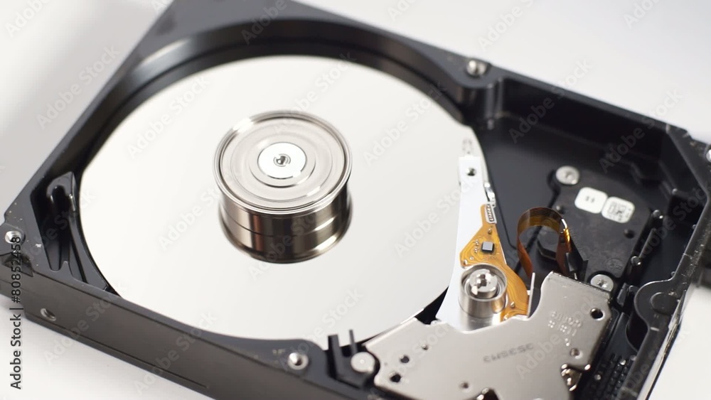Spinning disk drive with pin head reader reading data Spinning disk drive with pin head reader reading data