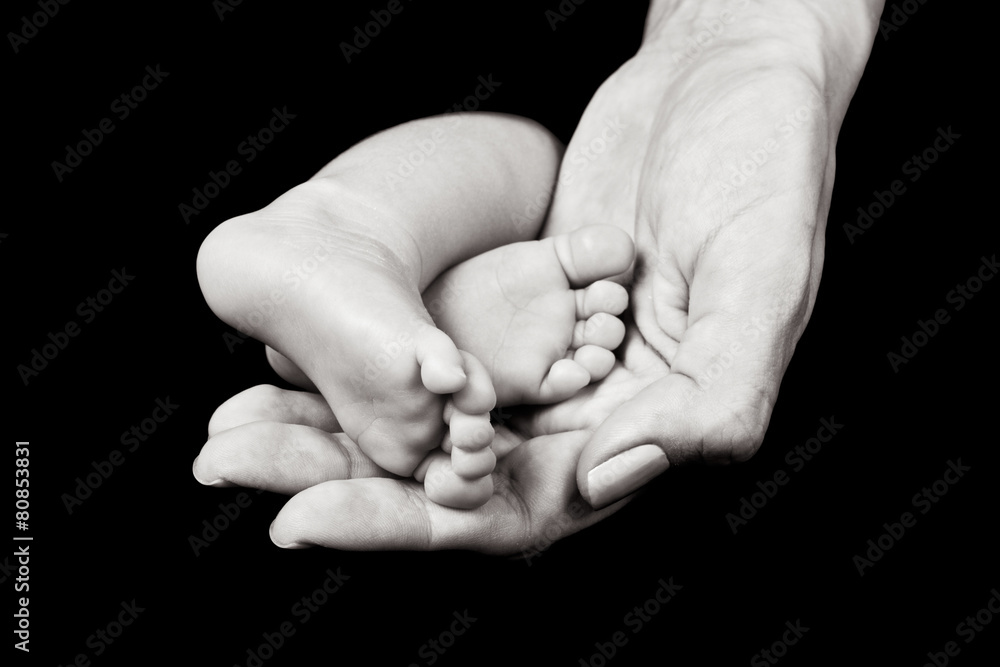 Black and white close up of mother's hand holding baby's feet Black and white close up of mother's hand holding baby's feet