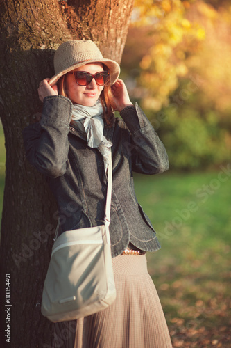Beautiful woman in hat and scarf enjoy sunlight in the city