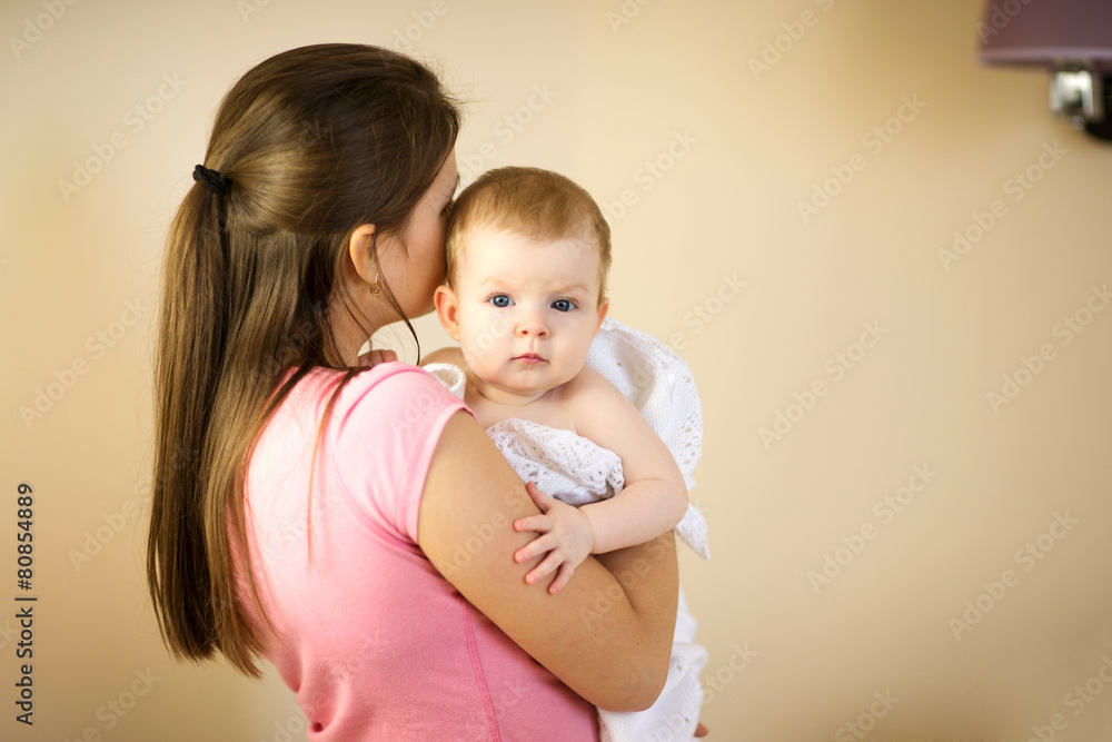 Young woman holding a baby in a towel Young woman holding a baby in a towel