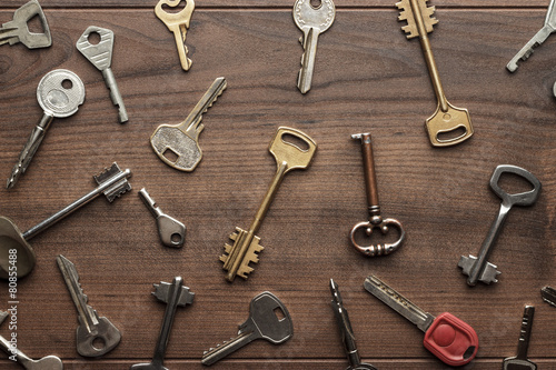 many different keys on wooden table