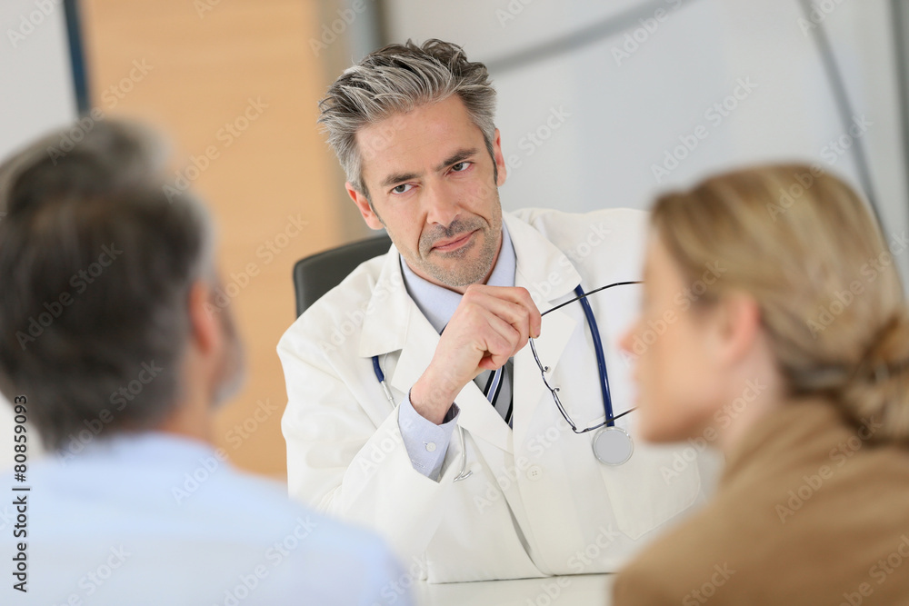 Doctor meeting couple in hospital office Doctor meeting couple in hospital office