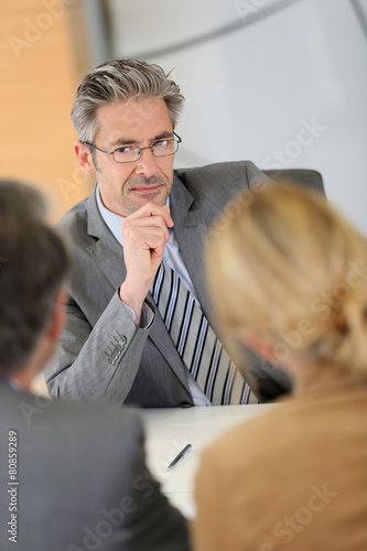 Consultant listening to clients in meeting photo