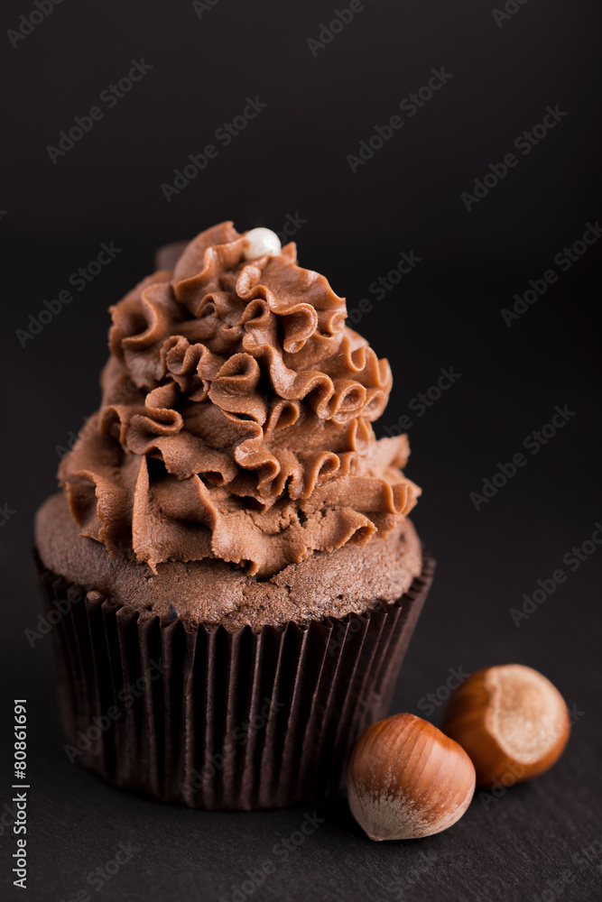 Chocolate cupcake with hazelnut on dark background Chocolate cupcake with hazelnut on dark background