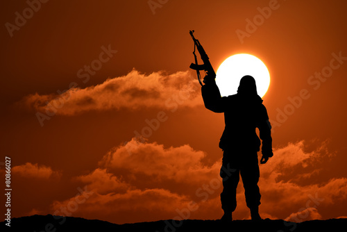 Silhouette of military soldier officer with weapons at sunset.