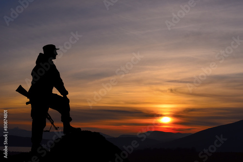 Silhouette of military soldier officer with weapons at sunset © dmitry_dmg