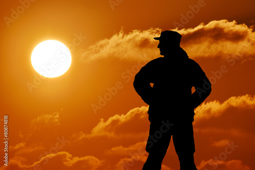 Silhouette of military soldier officer with weapons at sunset