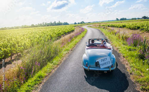 Photography A newlywed couple is driving a retro car, top view