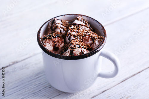 Mug of cocoa with marshmallows on wooden background
