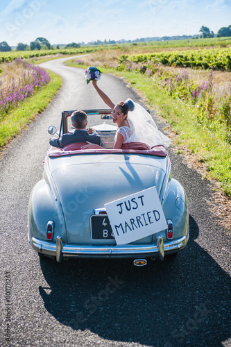 Top view, a newlywed couple is driving a retro car