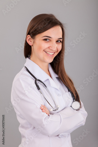 Young and beautiful nurse on a grey