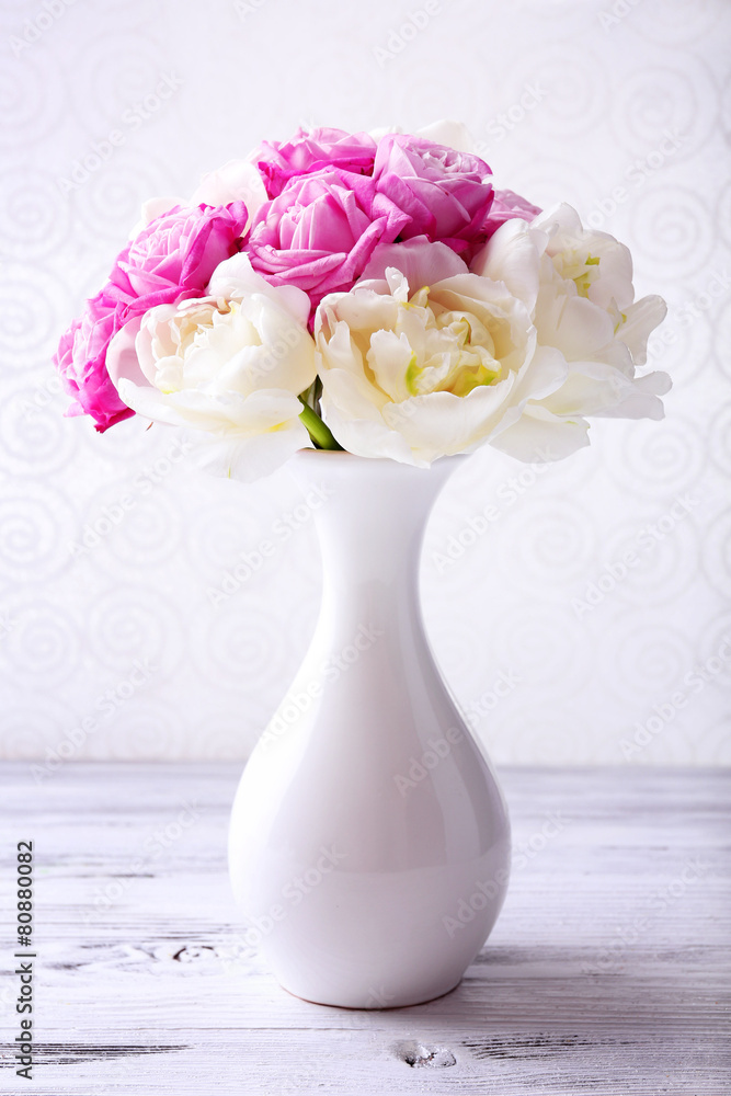 Bouquet of fresh roses and tulips on wallpaper background Bouquet of fresh roses and tulips on wallpaper background