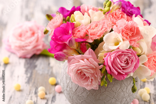 Beautiful fresh spring flowers in pot on wooden table, closeup