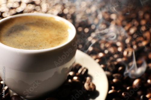 Cup of coffee with grains, closeup