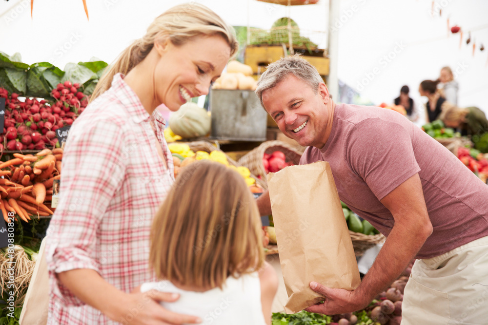 Family Buying Fresh Vegetables At Farmers Market Stall Family Buying Fresh Vegetables At Farmers Market Stall