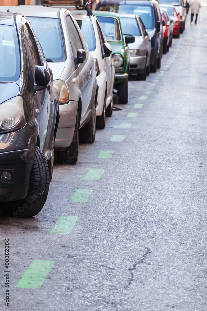 Obraz premium Reihe geparkter Autos am Straßenrand