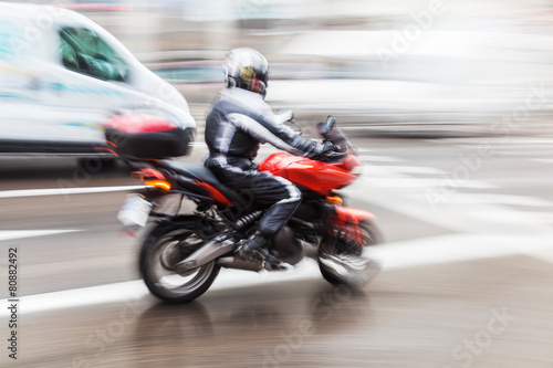 Motorrad auf nasser Stra  e in Bewegungsunsch  rfe
