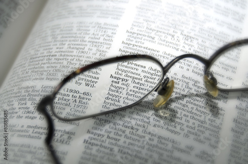 Happy Word from a Book Viewed Through Eyeglasses