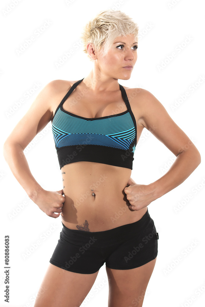 Blonde female fitness model posing in studio.