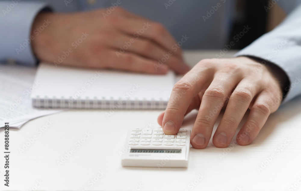 Businessmen counting on calculator and sitting at the tab Businessmen counting on calculator and sitting at the tab