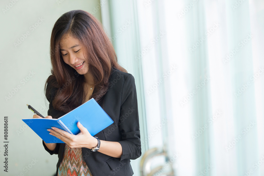 young asian business woman writing a note