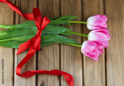 Top view of pink tulips with red ribbon and bow