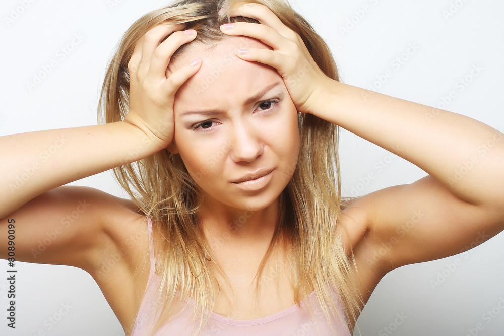 Fototapeta premium blond woman with a headache holding head