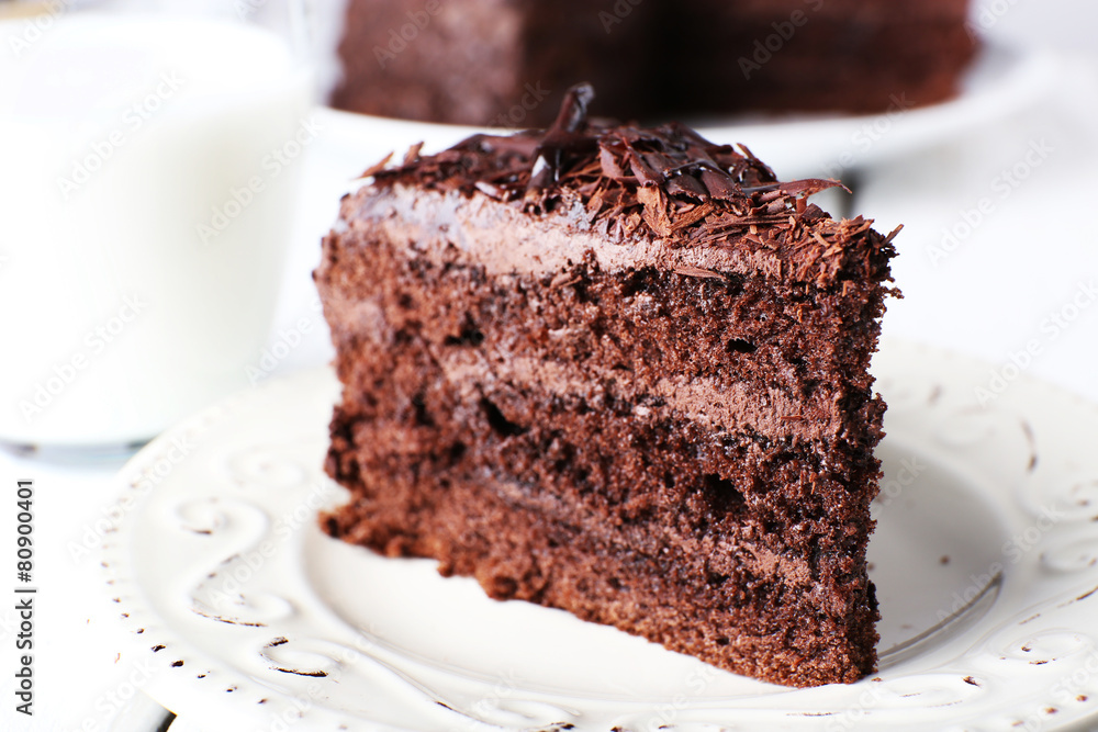 Sliced tasty chocolate cake in plate on wooden table, closeup Sliced tasty chocolate cake in plate on wooden table, closeup